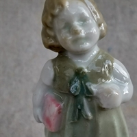 lysegrøn-kjole-med-sløjfe-lyserød-bog-under-armen-gammel-porcelænsfigur